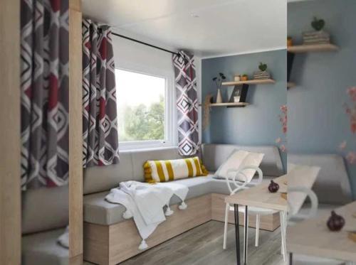 Cette petite chambre comprend un canapé et une fenêtre. dans l'établissement Camping 4 étoiles - Piscine - efceih, à LʼÎle-dʼOlonne