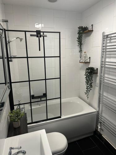 a bathroom with a tub and a toilet and a sink at The Olive in Market Rasen