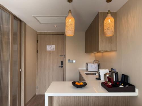 a kitchen with two pendant lights and a counter at Laya Suites and Residences in Bang Tao Beach