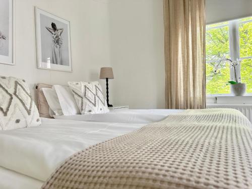 a white bed in a bedroom with a window at WOW, Föreningsgatan 9 in Gothenburg
