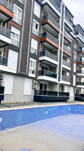 an apartment building with a swimming pool in front of it at Selinti City Tatil Evleri1&1 in Gazipasa