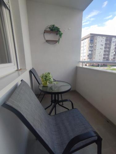 a small table and chairs in a balcony with a window at Stan na dan Paradiso in Lukavica