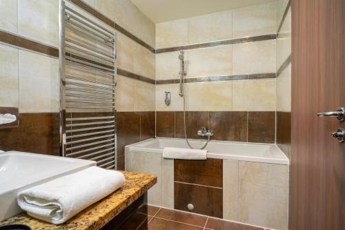 a bathroom with a bath tub and a sink at Hotel Castello & Thermal Spa Siklós in Siklós