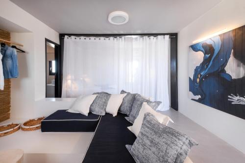 a living room with a couch and a large window at IfestAu.4 Suites in Fira