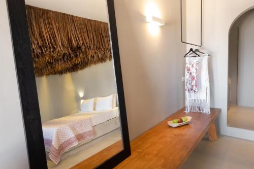 a mirror in a room with a bed and a table at IfestAu.4 Suites in Fira