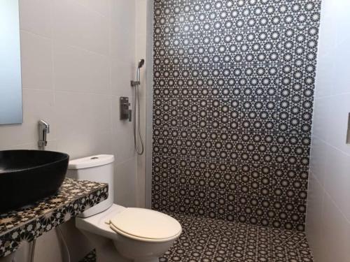 a bathroom with a shower with a toilet and a sink at Raintree Boutique Hotel in Kajang