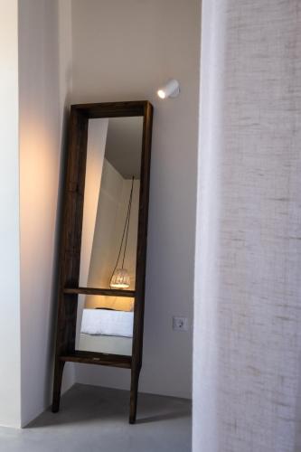 a mirror with a wooden frame in a room at IfestAu.4 Suites in Fira