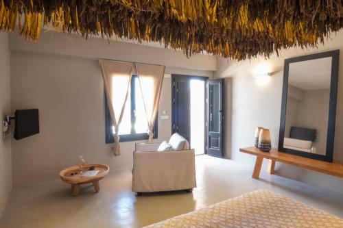 a living room with a couch and a table and a mirror at IfestAu.4 Suites in Fira