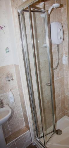 a shower with a glass door in a bathroom at Kirkwood Guest House in Windermere