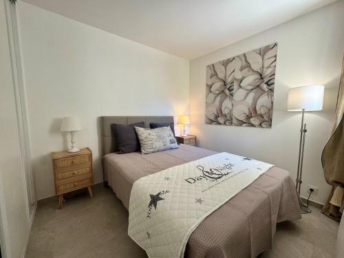 une chambre avec un lit et un tableau au mur dans l'établissement Appartement avec jardin - Cap d'Agde, au Cap d'Agde