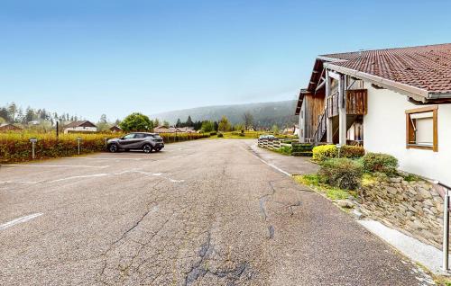une voiture garée dans un parking à côté d'une maison dans l'établissement Gorgeous Apartment In Gérardmer, à Gérardmer