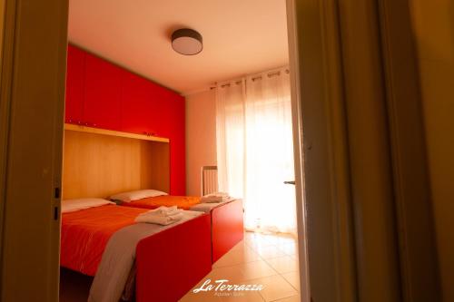 two beds in a room with red walls at La Terrazza in Noicattaro