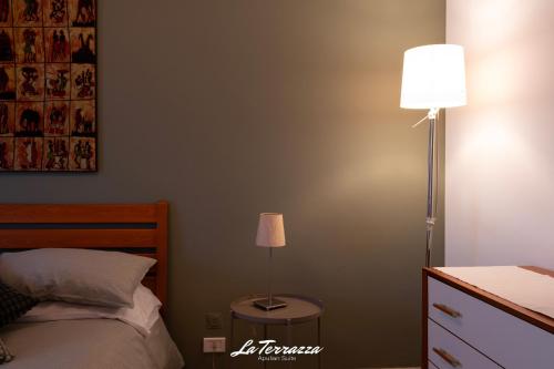 a bedroom with a bed and a floor lamp at La Terrazza in Noicattaro