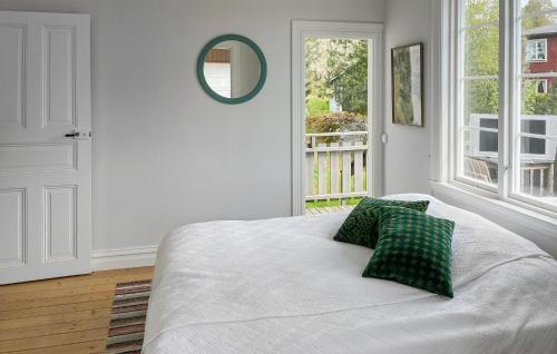 a bedroom with a bed with two pillows and a mirror at Gorgeous Home In Motala With Lake View in Motala