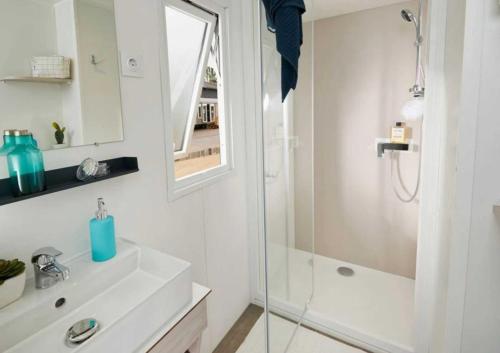 ein weißes Badezimmer mit Dusche und Waschbecken in der Unterkunft Camping 4 étoiles - Parc aquatique - ccadfdf in Saint-Jean-de-Monts