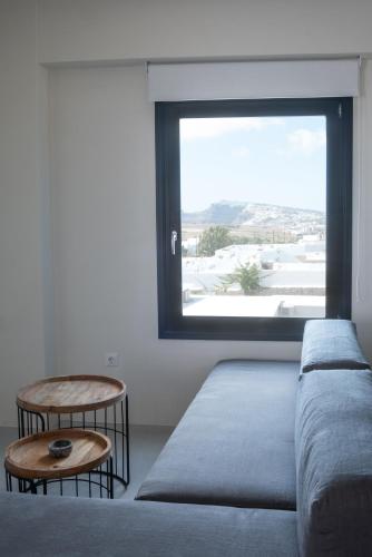 a living room with a couch and a large window at IfestAu.4 Suites in Fira
