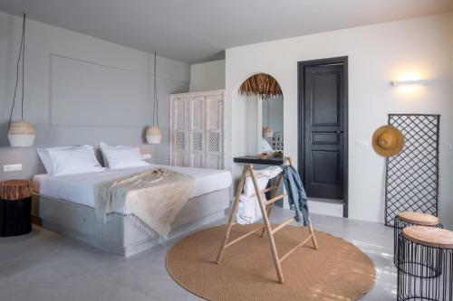 a white bedroom with a bed and a table at IfestAu.4 Suites in Fira