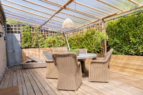 a patio with a table and chairs in a greenhouse at Fleur de Jasmin in Sint-Martens-Latem
