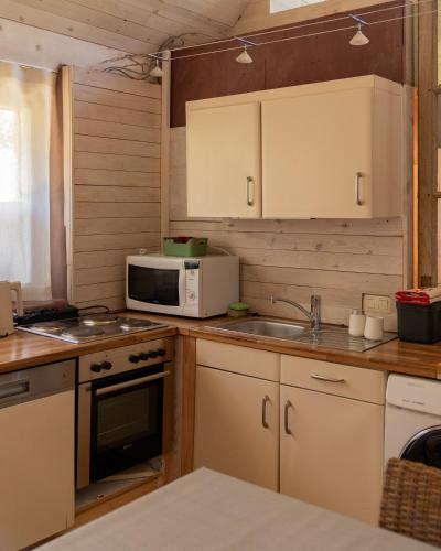 a kitchen with a sink and a microwave at Fleur de Jasmin in Sint-Martens-Latem