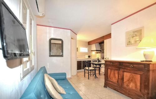un salon avec un canapé bleu et une cuisine dans l'établissement 1 Bedroom Nice Home In Banyuls Sur Mer, à Banyuls-sur-Mer