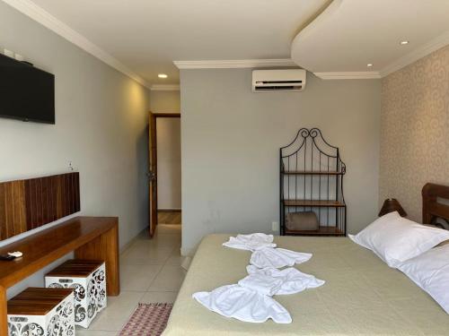 a room with two beds with towels laying on it at Pousada Maria Monteiro Tiradentes in Tiradentes