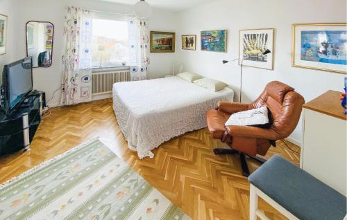 a bedroom with a bed and a chair and a television at 2 Bedroom Nice Home In Kungshamn in Kungshamn