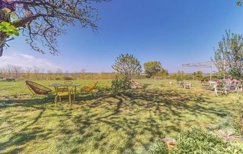 une table et des chaises assises dans un champ dans l'établissement Amazing Home In Villaines-La-Gonais, à Villaines-la-Gonais