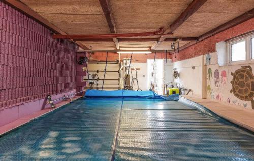 a swimming pool in a gym with an indoor swimming pool at Cozy Apartment In Åsljunga With Sauna in Åsljunga