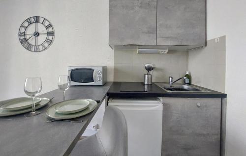 - une cuisine avec évier, four micro-ondes et verres à vin dans l'établissement Stunning Apartment In Saint-Malo, à Saint-Malo