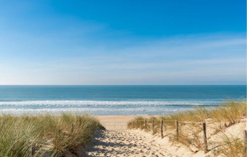 un chemin de sable menant à l'océan sur une plage dans l'établissement Gorgeous Stacaravan, à Saint-Julien-en-Born