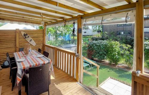 - une terrasse couverte avec une table et une vue sur la cour dans l'établissement Gorgeous Stacaravan, à Saint-Julien-en-Born