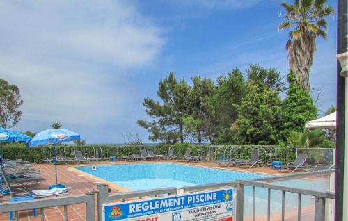 - une piscine dans un complexe avec des chaises et des parasols dans l'établissement Gorgeous Apartment In Moriani, à Moriani-Plage