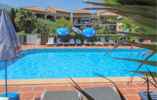 une grande piscine avec chaises et parasols dans l'établissement Gorgeous Apartment In Moriani, à Moriani-Plage