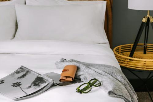 a pair of glasses and a book on a bed at Sonder by Marriott Bonvoy Village 21 Apartments Hillsboro Village in Nashville
