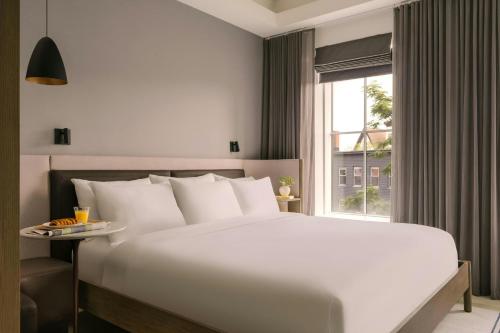 a bedroom with a large white bed and a window at 907 Main Hotel Central Square, Sonder by Marriott Bonvoy in Cambridge