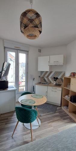 - une cuisine avec une table et deux chaises dans une pièce dans l'établissement Studio NOTRE-DAME 2 coeur de ville, à Cholet