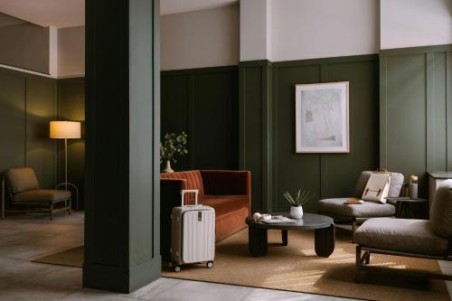a living room with green walls and a suitcase at Sonder by Marriott Bonvoy The Dutch Apartments Long Island City in Long Island City