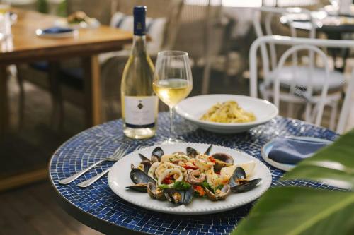 a table with a plate of mussels and a bottle of wine at Beverly Terrace Hotel Beverly Hills, Sonder by Marriott Bonvoy in Los Angeles