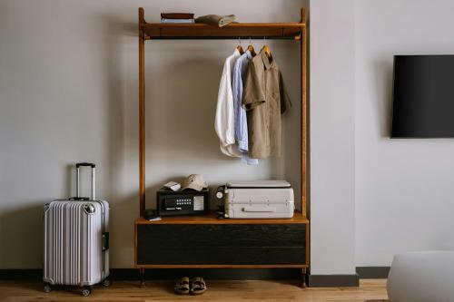 a room with a shelf with a suitcase and clothes at The Dutch Hotel Long Island City, Sonder by Marriott Bonvoy in Long Island City
