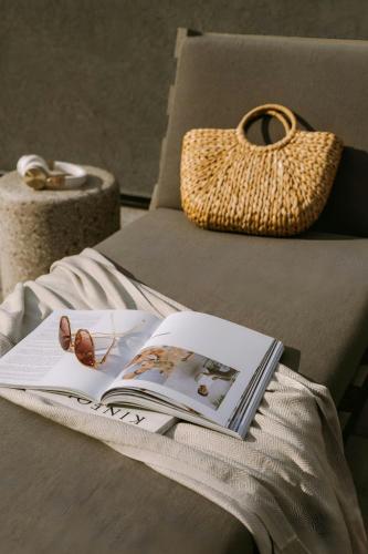 a book and sunglasses on a couch with a purse at The Dutch Hotel Long Island City, Sonder by Marriott Bonvoy in Long Island City