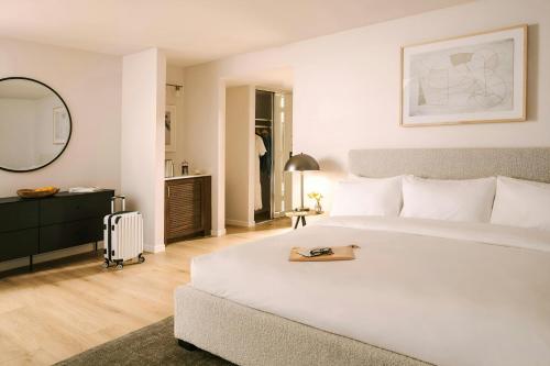 a bedroom with a large white bed and a mirror at La Ensenada Hotel Laguna Beach, Sonder by Marriott Bonvoy in Laguna Beach