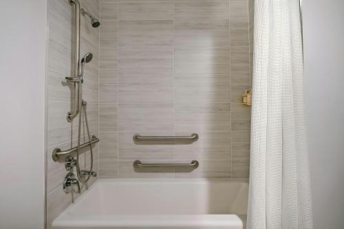 a bathroom with a bath tub with a shower curtain at Sonder by Marriott Bonvoy The Winfield Apartments Downtown LA in Los Angeles