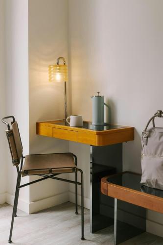 a wooden table with a lamp and a chair at Henri on 24 Hotel Chelsea, Sonder by Marriott Bonvoy in New York