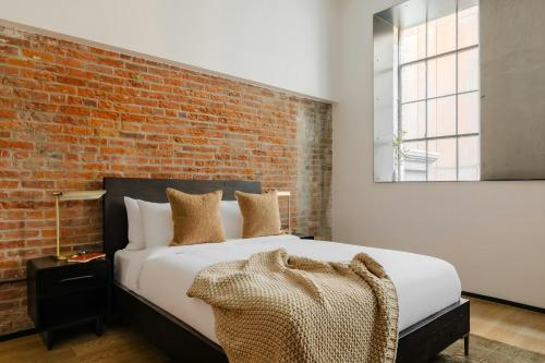 a bedroom with a bed with a brick wall at Sonder by Marriott Bonvoy RailSpur Apartments Pioneer Square in Seattle