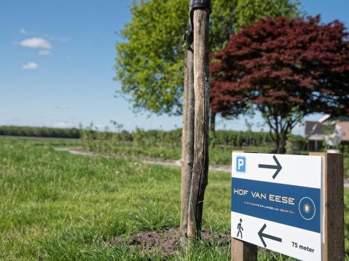 a sign on a pole next to a tree at Hof van Eese - Rust, Ruimte en Landelijk Genieten in Eesveen