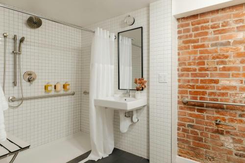 a bathroom with a sink and a brick wall at Sonder by Marriott Bonvoy RailSpur Apartments Pioneer Square in Seattle