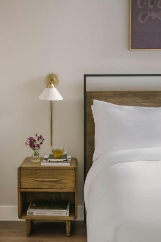 a bed with a nightstand next to a bed with a lamp at Sonder by Marriott Bonvoy North Loop Green Apartments North Loop in Minneapolis