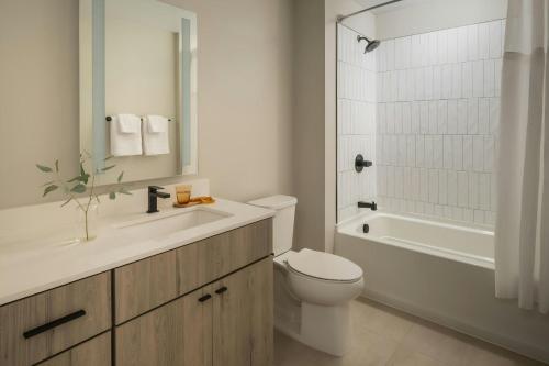 a bathroom with a toilet and a sink and a tub at Sonder by Marriott Bonvoy North Loop Green Apartments North Loop in Minneapolis