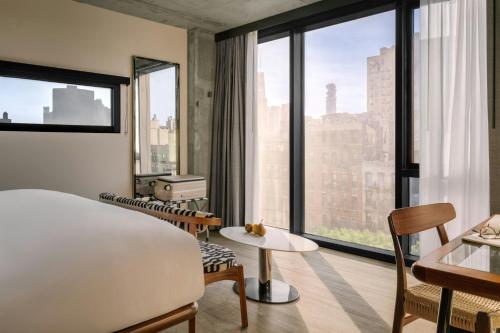 a hotel room with a bed and a large window at The Merchant Hotel Lower East Side, Sonder by Marriott Bonvoy in New York