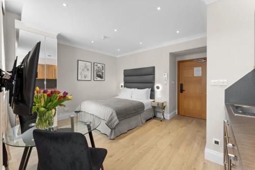 a hotel room with a bed and a desk with a television at Cleveland Residences Russell Square in London